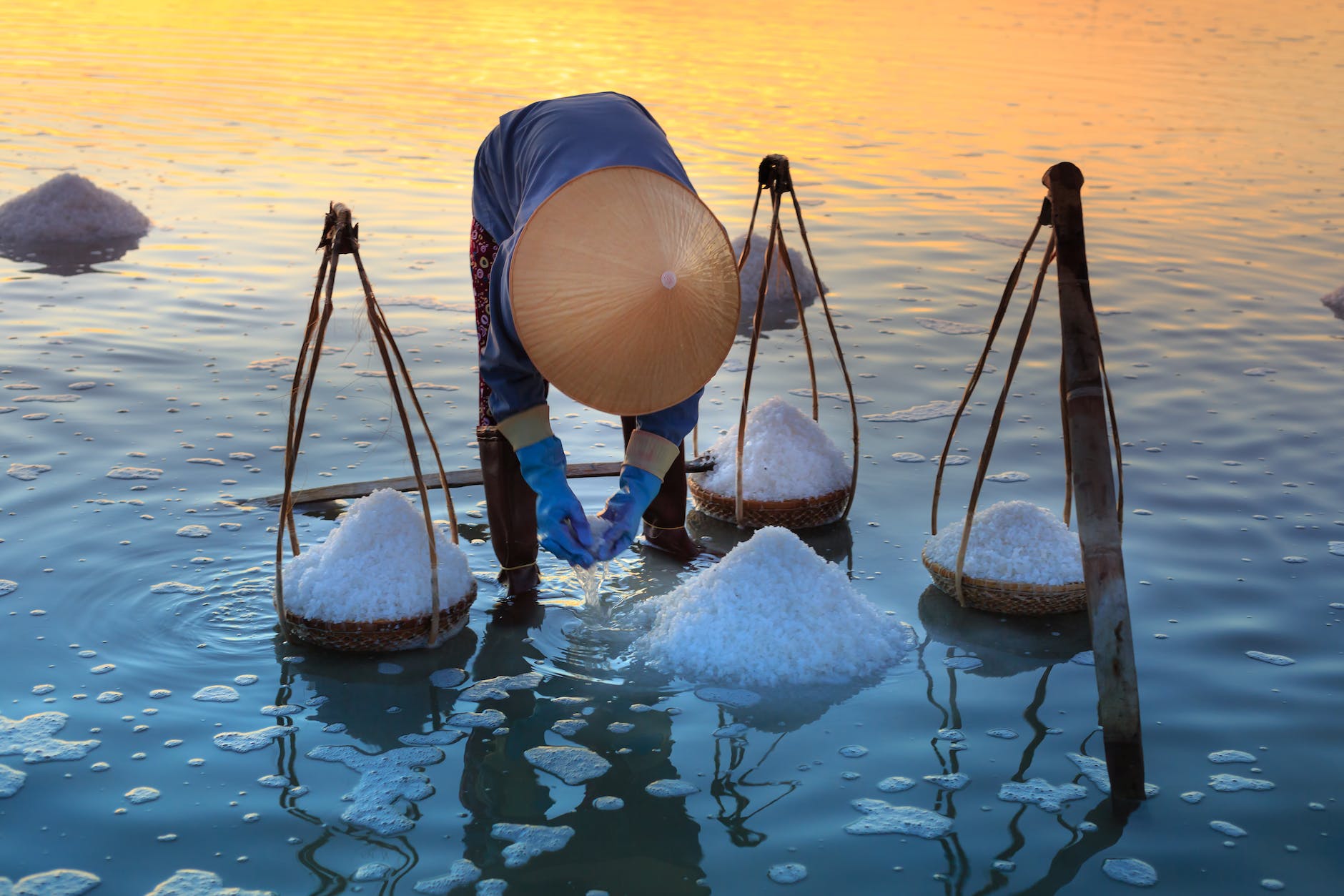 person collecting salt on body of water